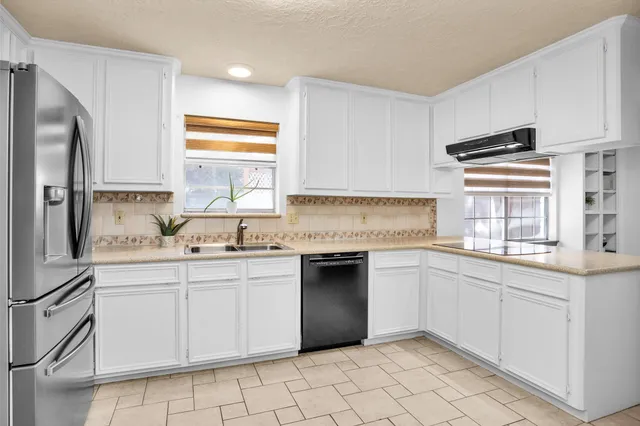 a kitchen with granite countertop white cabinets and white appliances