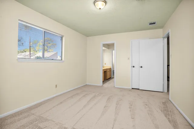 a spacious bathroom with a double vanity sink toilet and mirror