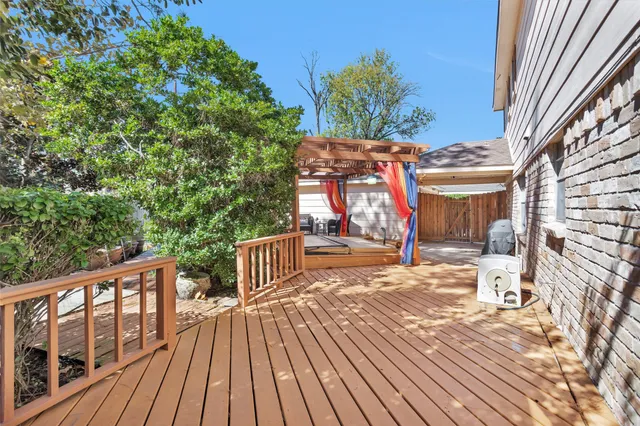 a view of a white house with a yard and table and chairs under an umbrella