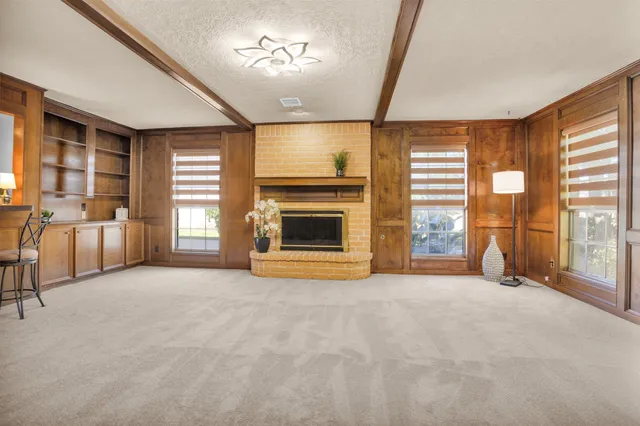 a view of an empty room with a fireplace and a window