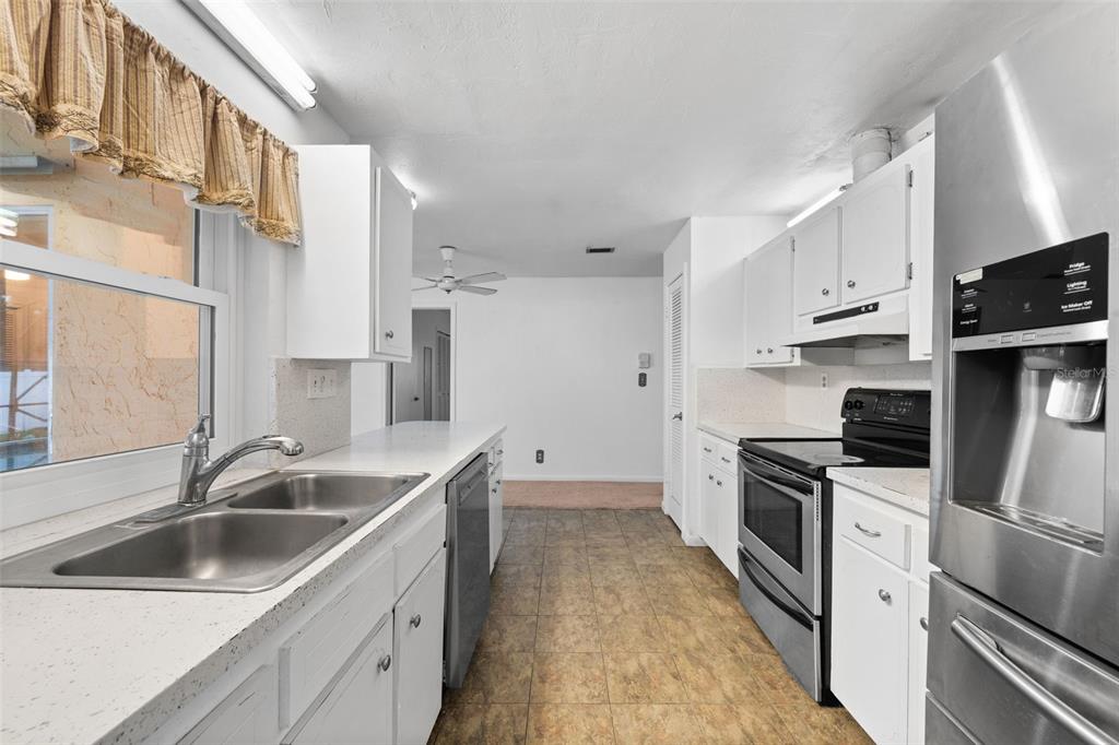 1540 Northwest 10th Street Boca Raton, FL 33486 - Photo 15 of 38 a kitchen with white cabinets sink and stainless steel appliances