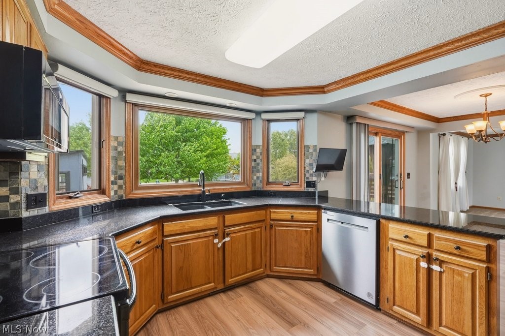 5321 Young Road Stow, OH 44224 - Photo 17 of 37 Kitchen featuring ample wood cabinetry, dark stone countertops, a multi-paned bay window, and a stainless steel dishwasher