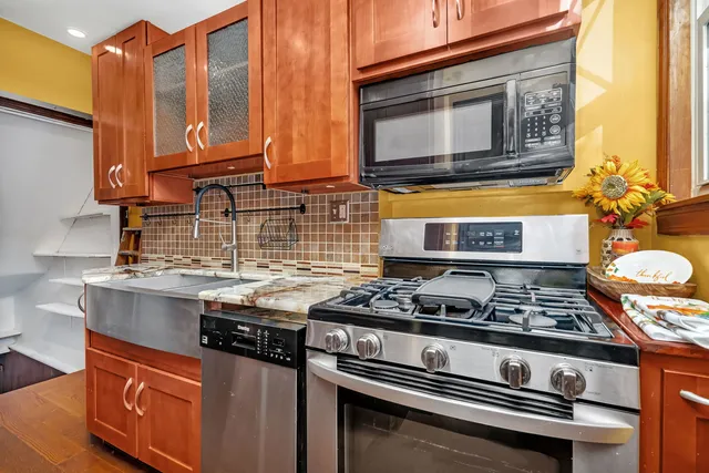 a kitchen with stainless steel appliances granite countertop a stove and a microwave