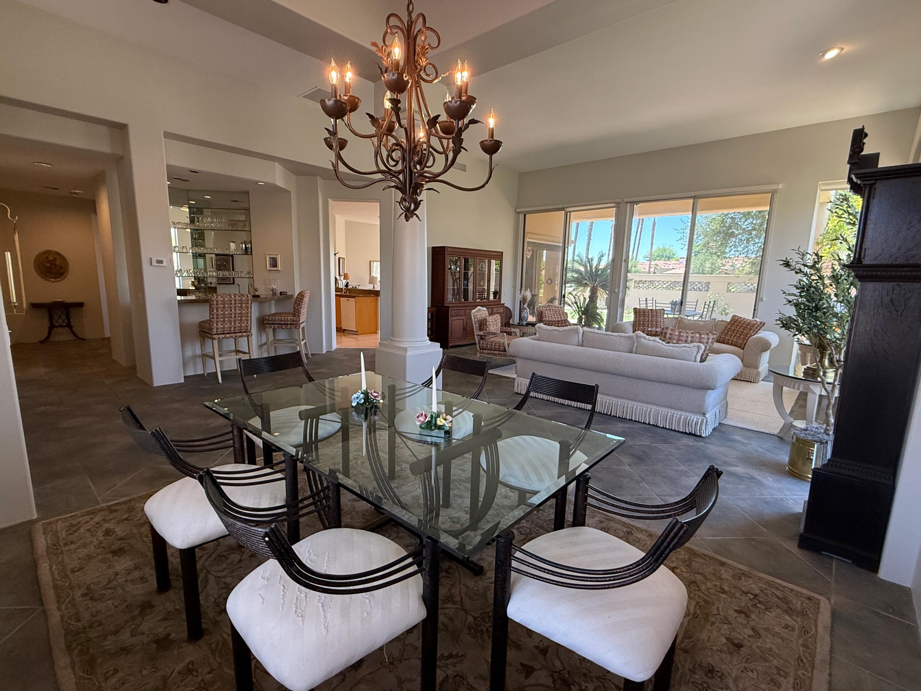 79765 Tangelo La Quinta, CA 92253 - Photo 13 of 55 a view of a dining room with furniture a livingroom and chandelier