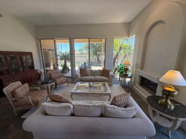 a living room with furniture fireplace and a large window