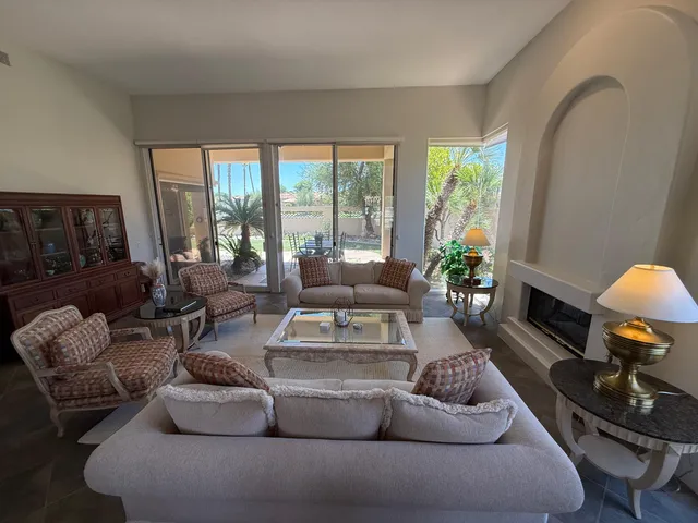 a living room with furniture fireplace and a large window