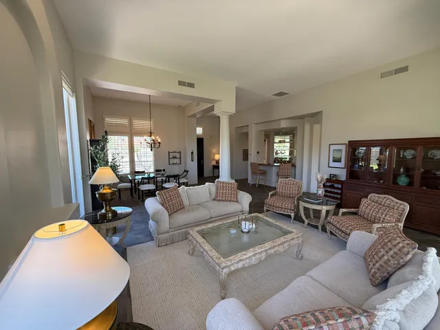 a living room with furniture fireplace and a large window