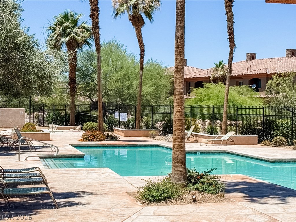 7701 West Robindale Road, Unit 110 Las Vegas, NV 89113 - Photo 18 of 21 A refreshing pool awaits, set amidst swaying palm trees and residential charm.