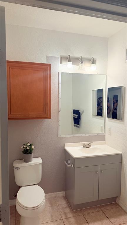 6137 Metrowest Boulevard, Unit 307 Orlando, FL 32835 - Photo 15 of 28 a bathroom with a toilet a sink a mirror and vanity