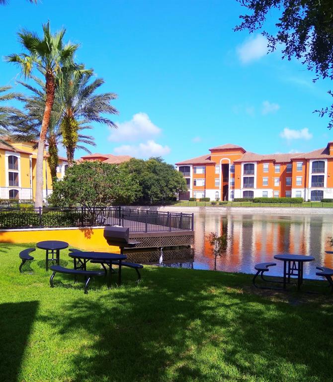 6137 Metrowest Boulevard, Unit 307 Orlando, FL 32835 - Photo 25 of 28 a view of a house with a swimming pool and a yard
