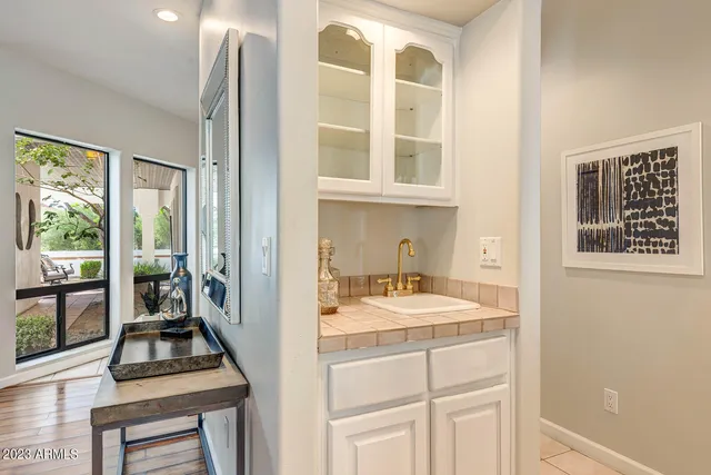a kitchen with white cabinets and sink