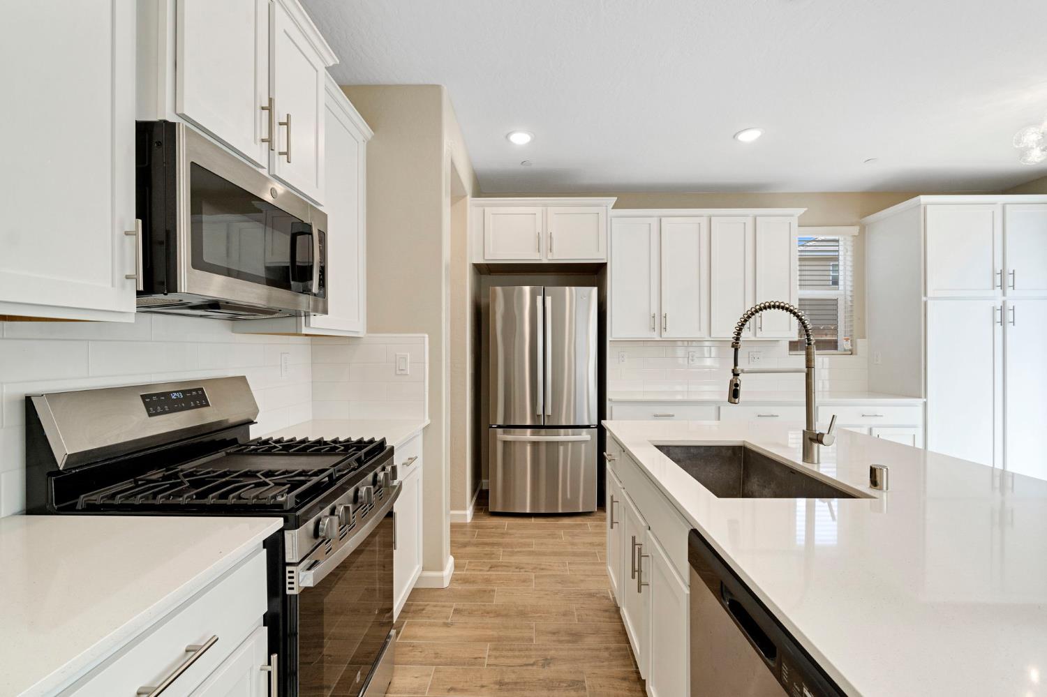1116 Encore Way West Madera, CA 93636 - Photo 14 of 35 a kitchen with refrigerator a stove sink and microwave