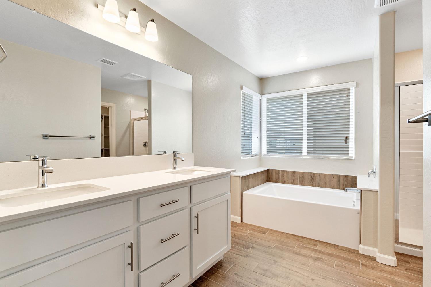 1116 Encore Way West Madera, CA 93636 - Photo 26 of 35 a spacious bathroom with a tub double sink and mirror