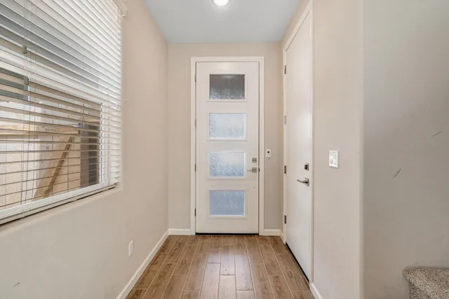 a view of a hallway with wooden floor and closet