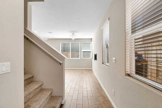 a view of a hallway with wooden floor and staircase