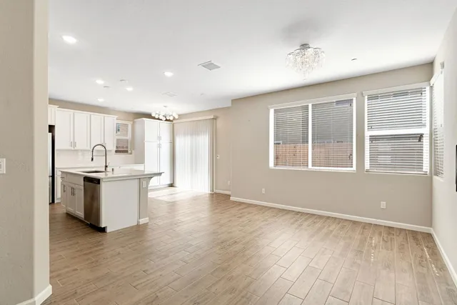 a view of a kitchen with a sink wooden floor and a window