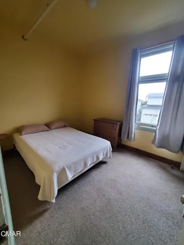 a bed room with a bed tv and a large window