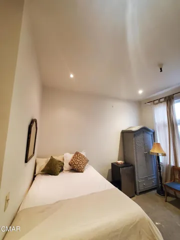 a spacious bedroom with a bed and a chandelier