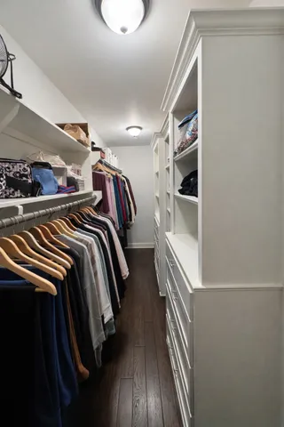 a view of walk in closet with clothes and shoes