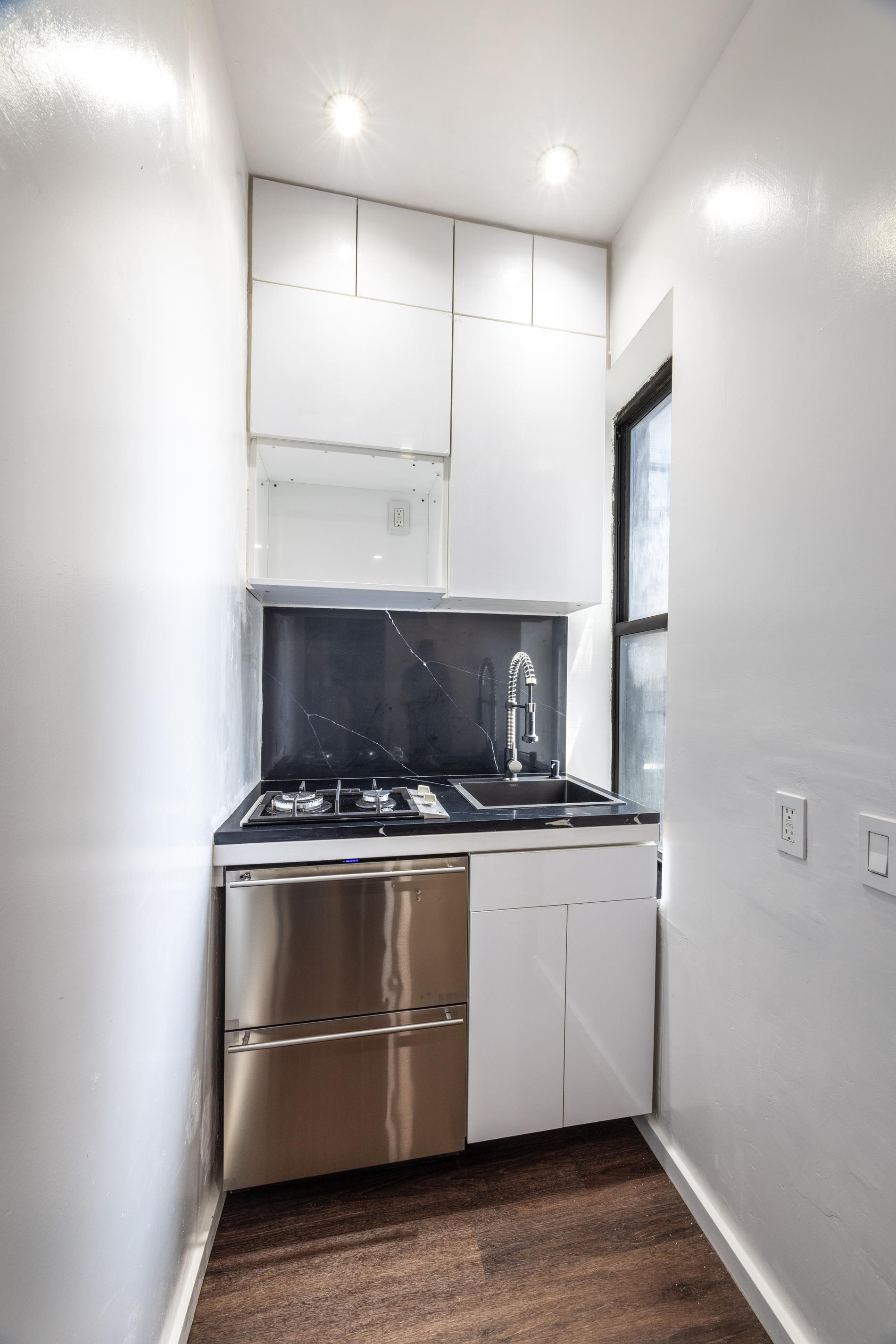 96 Perry Street, Unit B17B Manhattan, NY 10014 - Photo 2 of 8 a stove top oven sitting inside of a kitchen