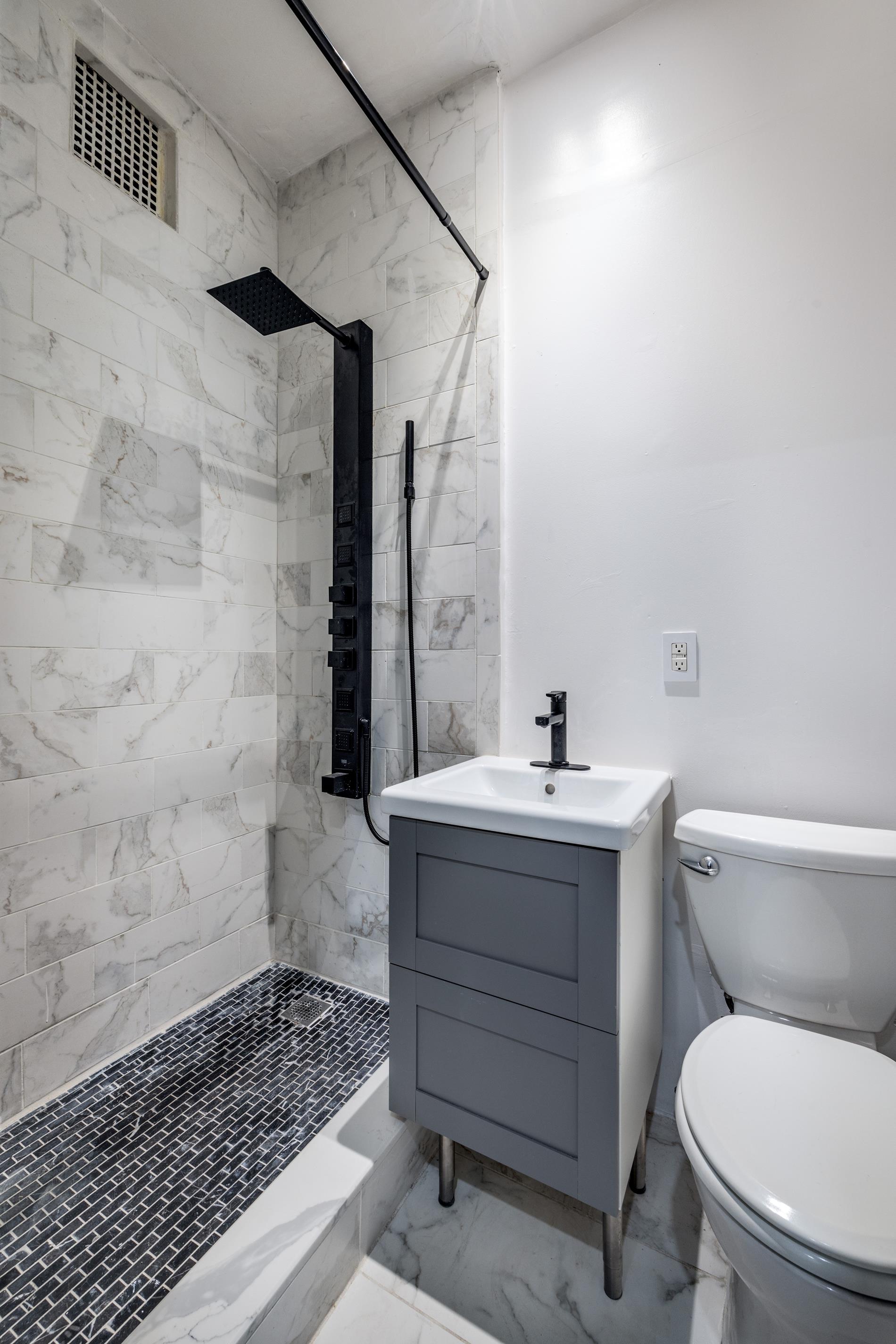 96 Perry Street, Unit B17B Manhattan, NY 10014 - Photo 3 of 8 a bathroom with a sink toilet and shower