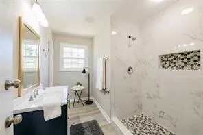 a bathroom with a sink a mirror and a shower