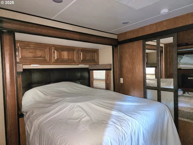 a bedroom with a bed and large mirror