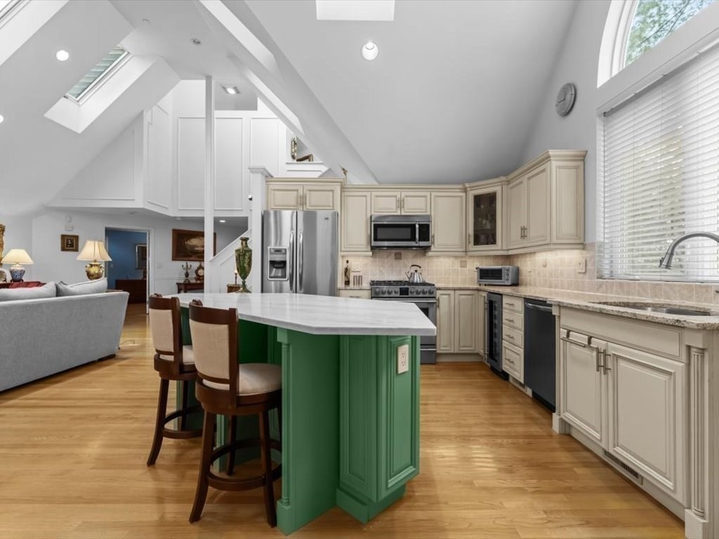 29 Deer Path, Unit 29 Hudson, MA 01749 - Photo 17 of 42 a kitchen with stainless steel appliances kitchen island granite countertop a table chairs microwave and sink