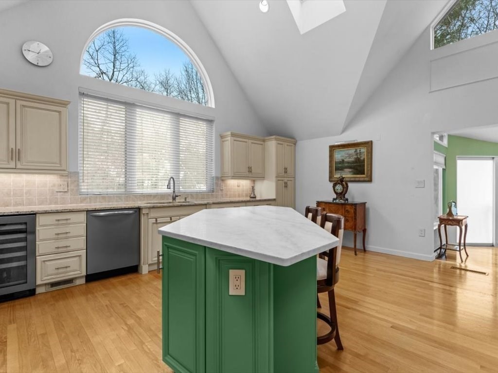 29 Deer Path, Unit 29 Hudson, MA 01749 - Photo 18 of 42 a kitchen with kitchen island granite countertop a stove a sink a refrigerator dining table and chairs with wooden floor