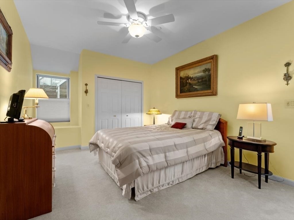 29 Deer Path, Unit 29 Hudson, MA 01749 - Photo 30 of 42 a bedroom with a bed and a lamp with window