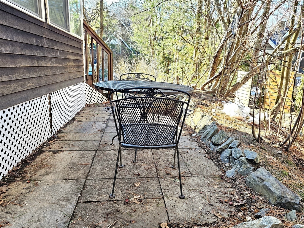 29 Deer Path, Unit 29 Hudson, MA 01749 - Photo 36 of 42 a view of backyard with a table and chairs and a large tree