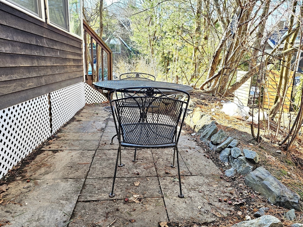 29 Deer Path, Unit 29 Hudson, MA 01749 - Photo 38 of 42 a view of backyard with a table and chairs and a large tree