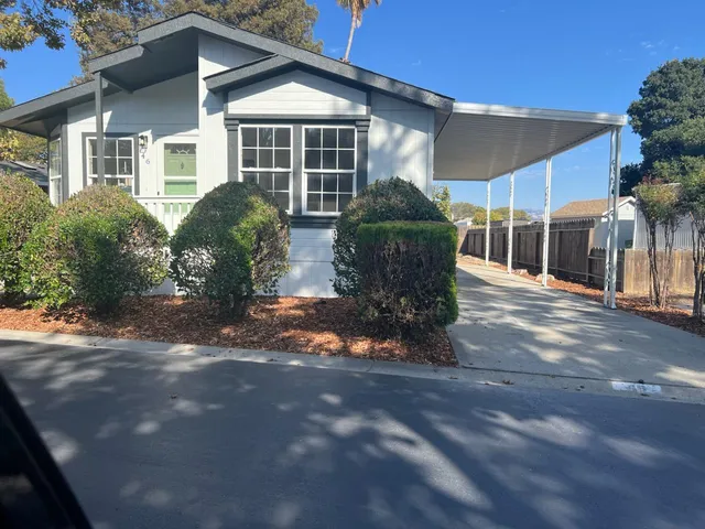 a front view of house with yard and trees in the background