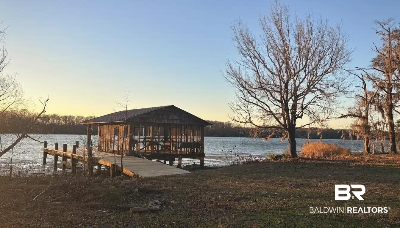 8008 Patricks Landing Road Bay Minette, AL 36507 - Photo 30 of 33 Waterfront property featuring a private boat dock with an enclosed boathouse, a ramp, and mature trees along the shoreline