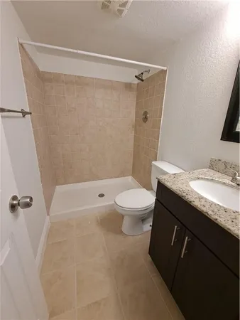 a bathroom with a granite countertop sink toilet and shower