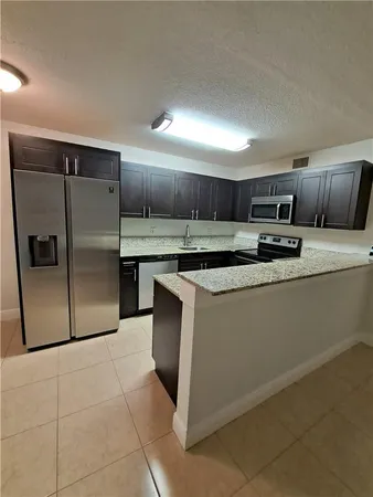 a kitchen with stainless steel appliances granite countertop a refrigerator and a stove