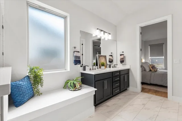a spacious bathroom with a granite countertop sink and a mirror