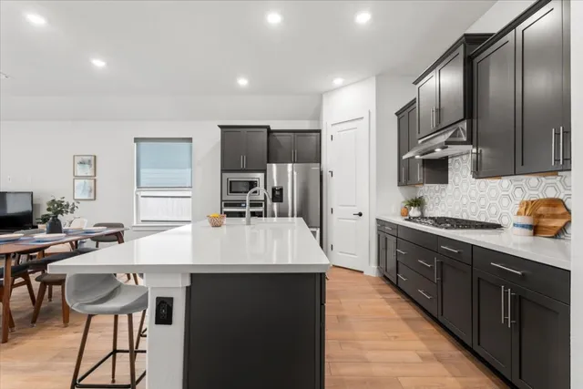 a kitchen with stainless steel appliances kitchen island granite countertop a sink and cabinets