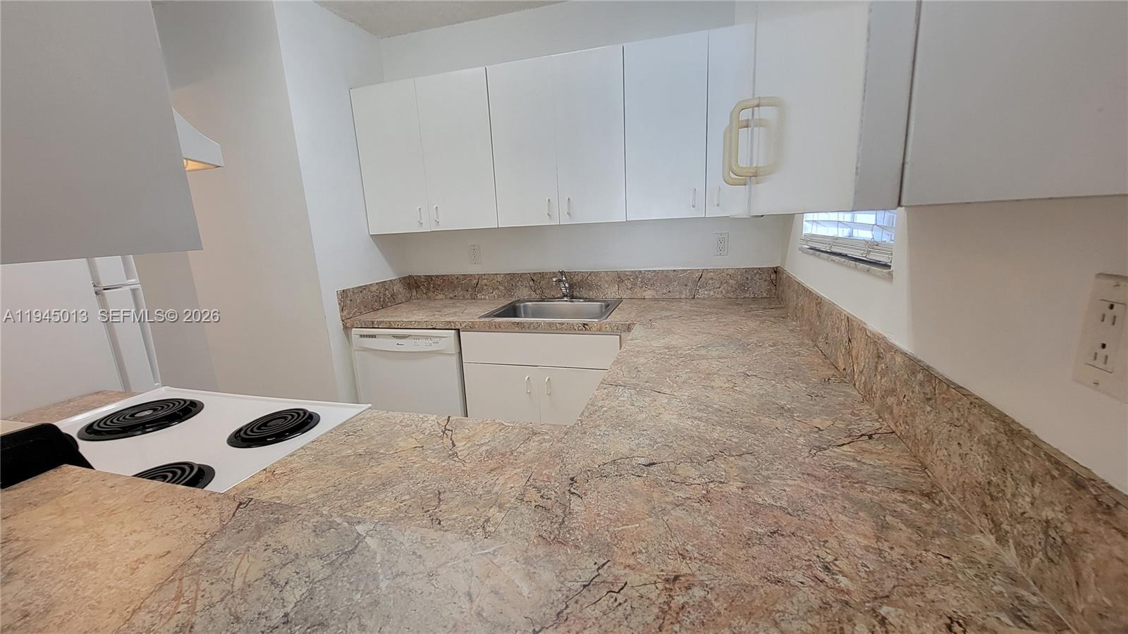 126 Southwest 17th Road, Unit 507 Miami, FL 33129 - Photo 9 of 13 a kitchen with a stove and a white cabinets