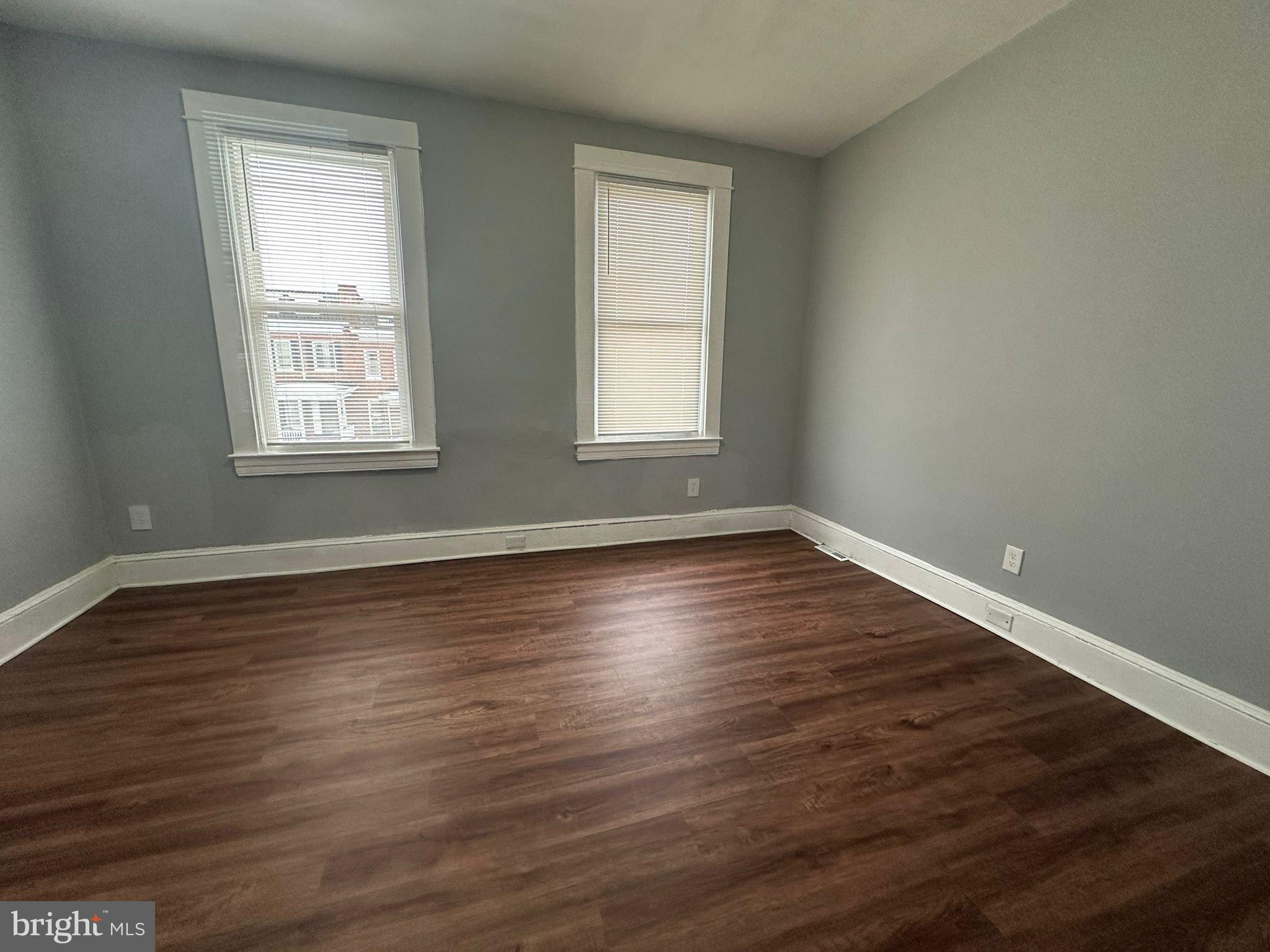 2806 Violet Avenue Baltimore, MD 21215 - Photo 5 of 10 a view of an empty room with wooden floor and a window