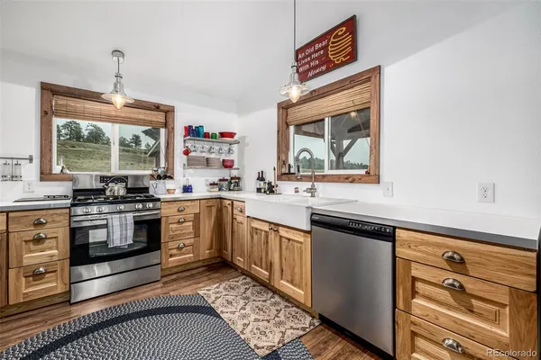 a kitchen with granite countertop a stove a sink and a microwave
