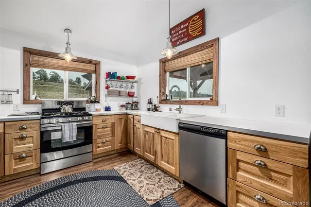 a kitchen with granite countertop a stove a sink and a microwave