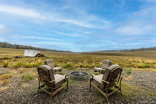 a view of a lake with beach and large trees