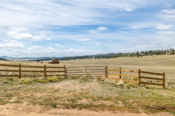 a backyard of a house with lawn chairs and wooden fence