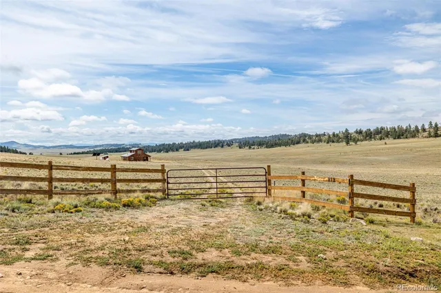 a backyard of a house with lawn chairs and wooden fence
