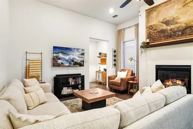 a living room with furniture a fireplace and a large window