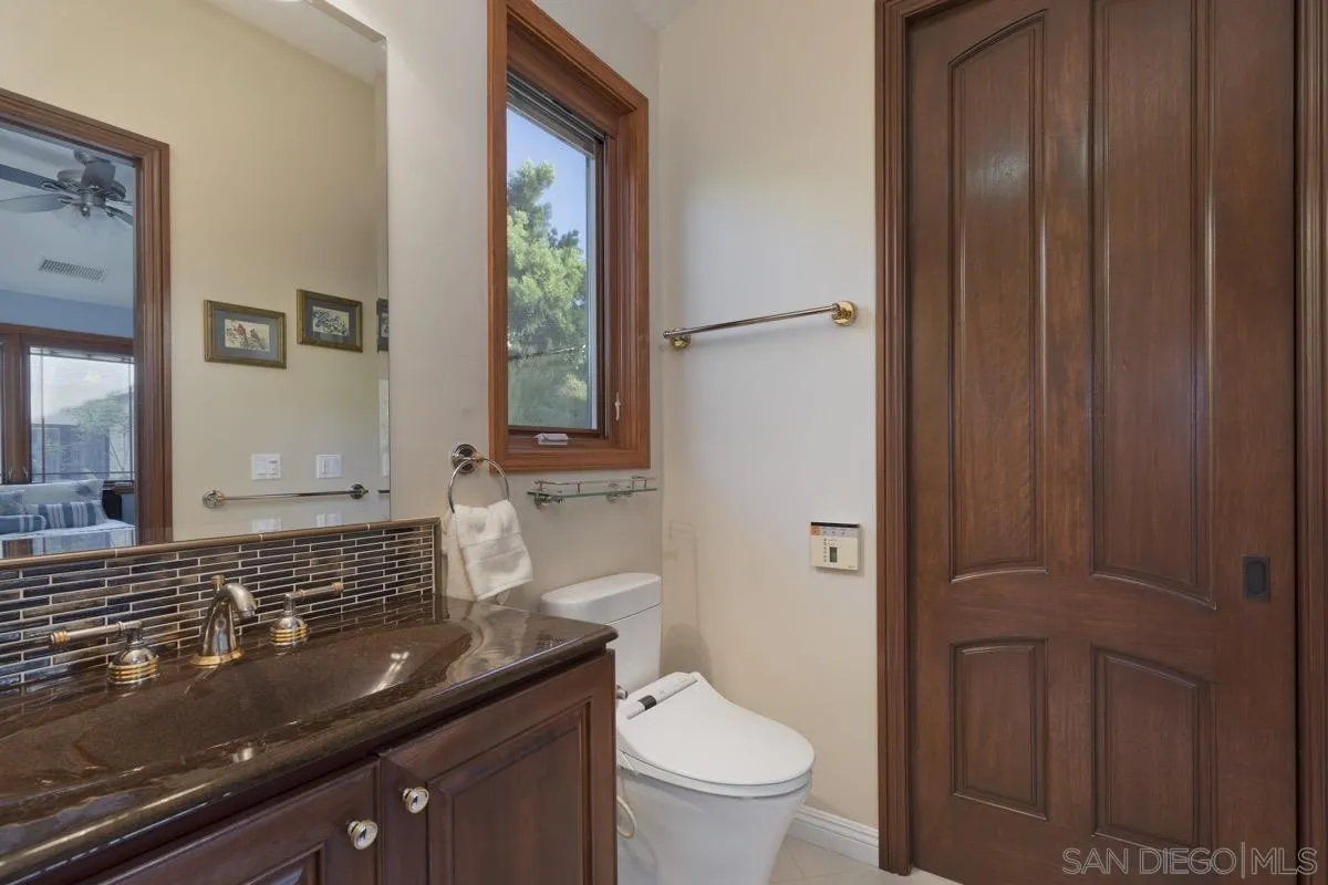 14401 Sandhill Road Poway, CA 92064 - Photo 45 of 75 a bathroom with a granite countertop sink toilet and mirror