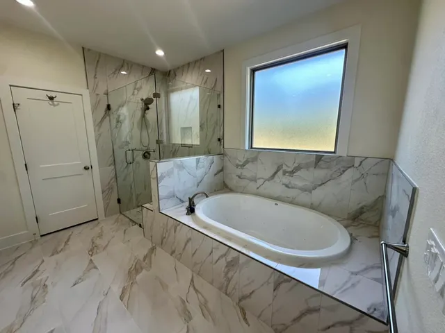 a bathroom with a tub sink and mirror