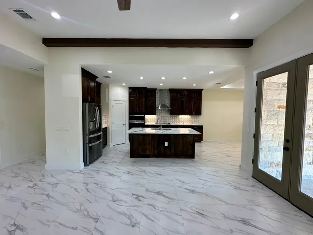 a large kitchen with stainless steel appliances a refrigerator and a sink