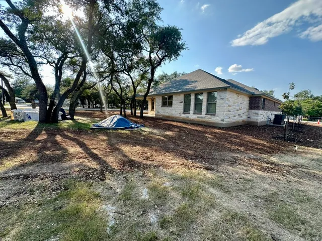 a front view of a house with a yard and trees